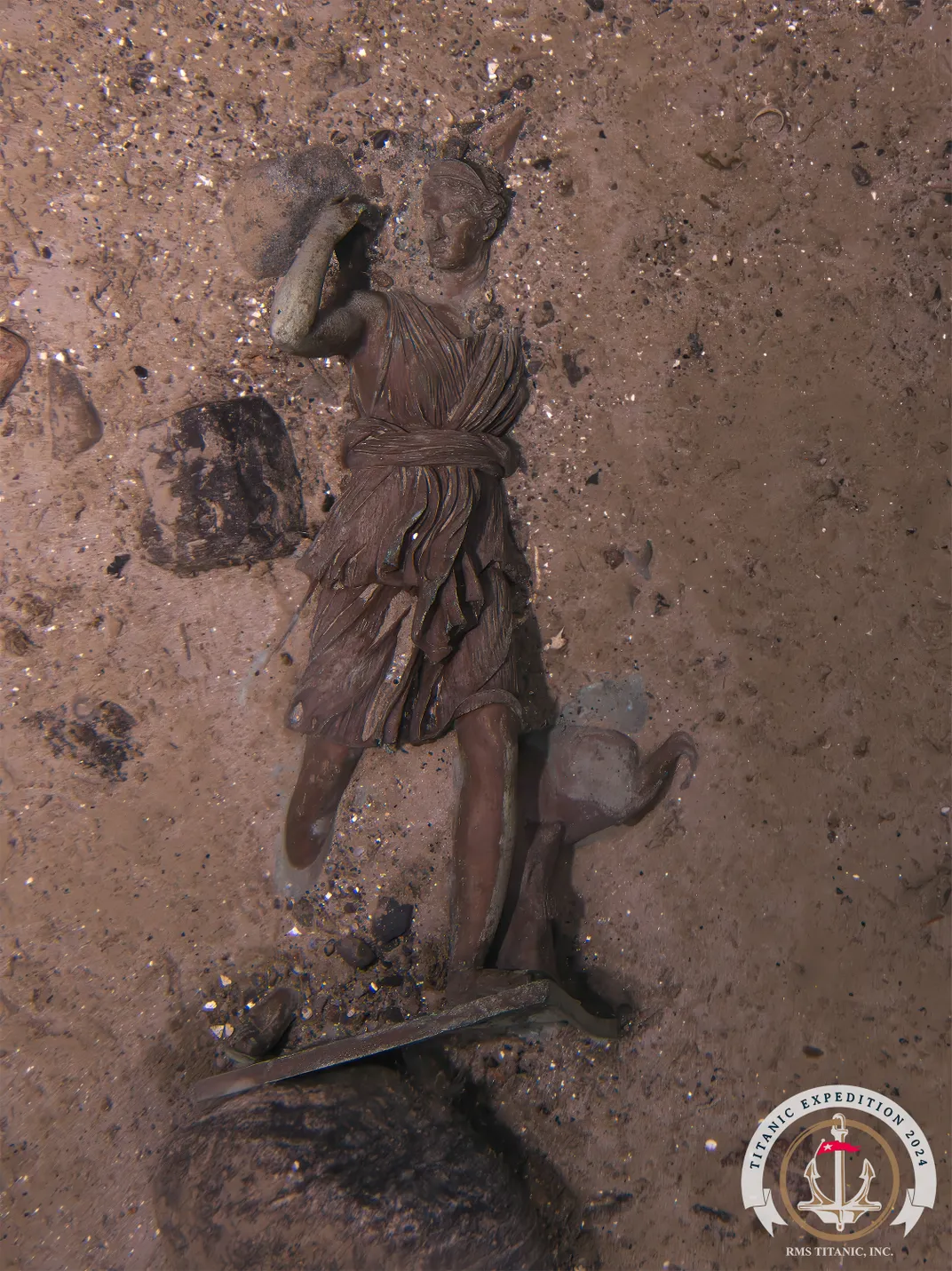 a statue of a woman partially buried in sand