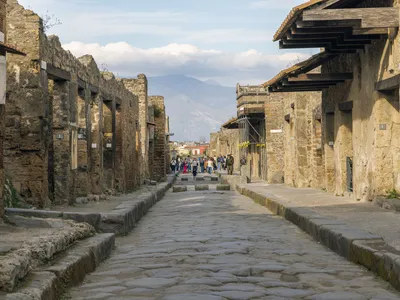 Tourists walk along the Via dell&#39;Abbondanza, one of&nbsp;Pompeii&#39;s major streets.