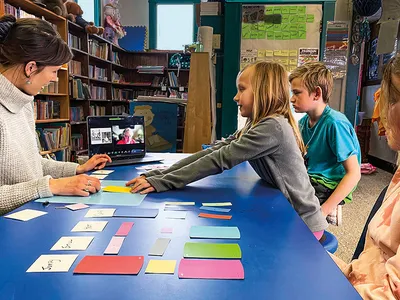 a classroom of students take instructions from their teacher