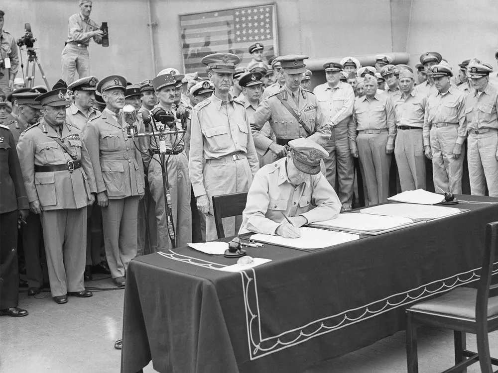 The 31-star Perry flag is visible in the background of this photo of United States General Douglas MacArthur signing the official Japanese surrender on September 2, 1945.