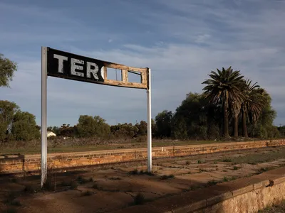 A tattered sign on an abandoned railway stop